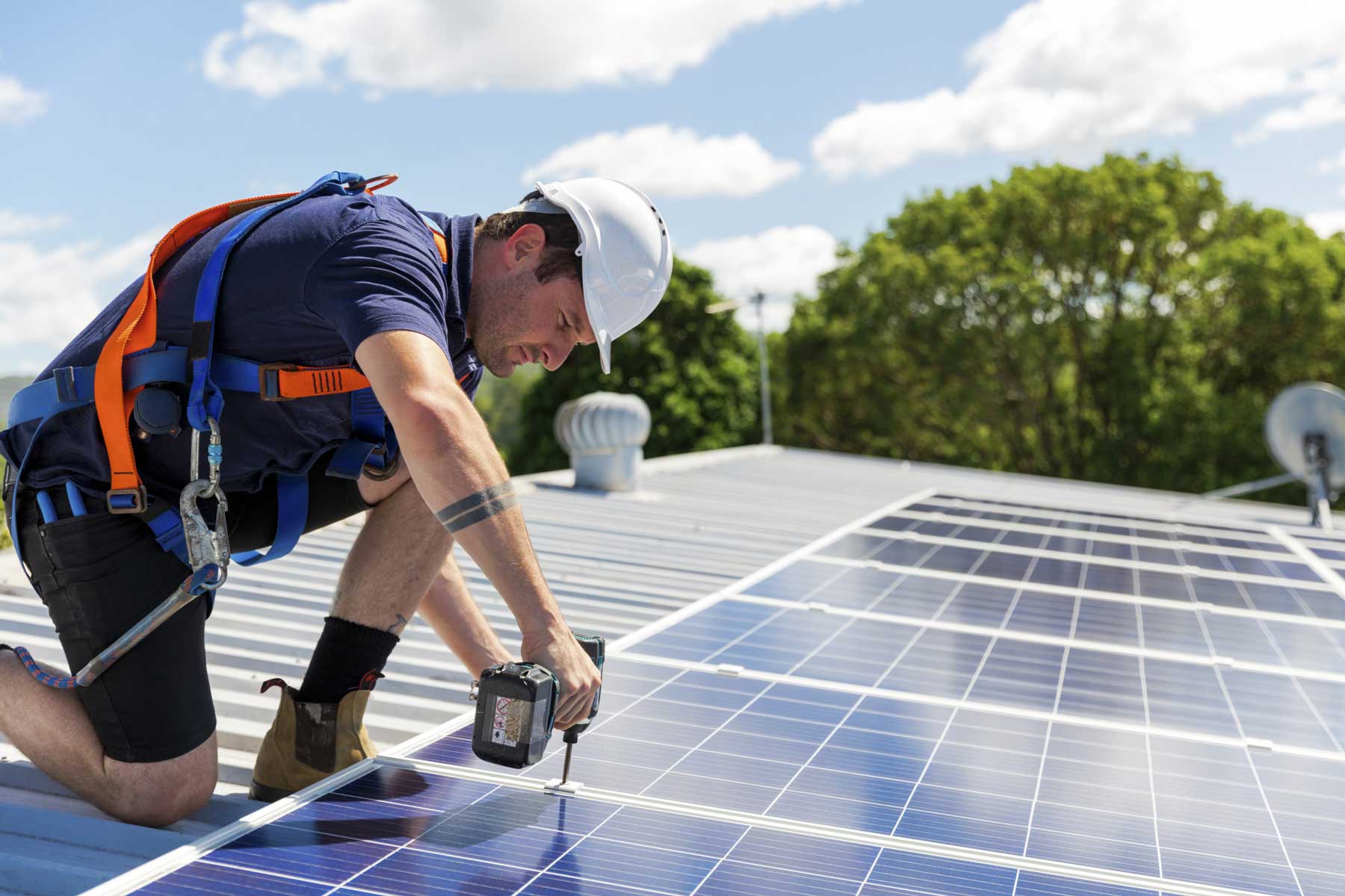 A Man Installing Solar Panels On The Roof Of A House- Residential Solar Roofing Nashville - Music City Solar Solutions 2306 Eugenia Ave Suite A Nashville TN 37211 (615) 692-1602